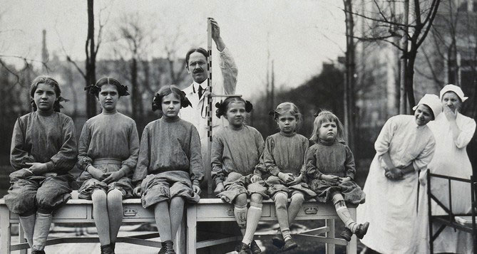 University Children's Hospital, Vienna: a row of girl patients, outdoors, being measured for height. Photograph, 1921. Credit: Wellcome Collection. CC BY